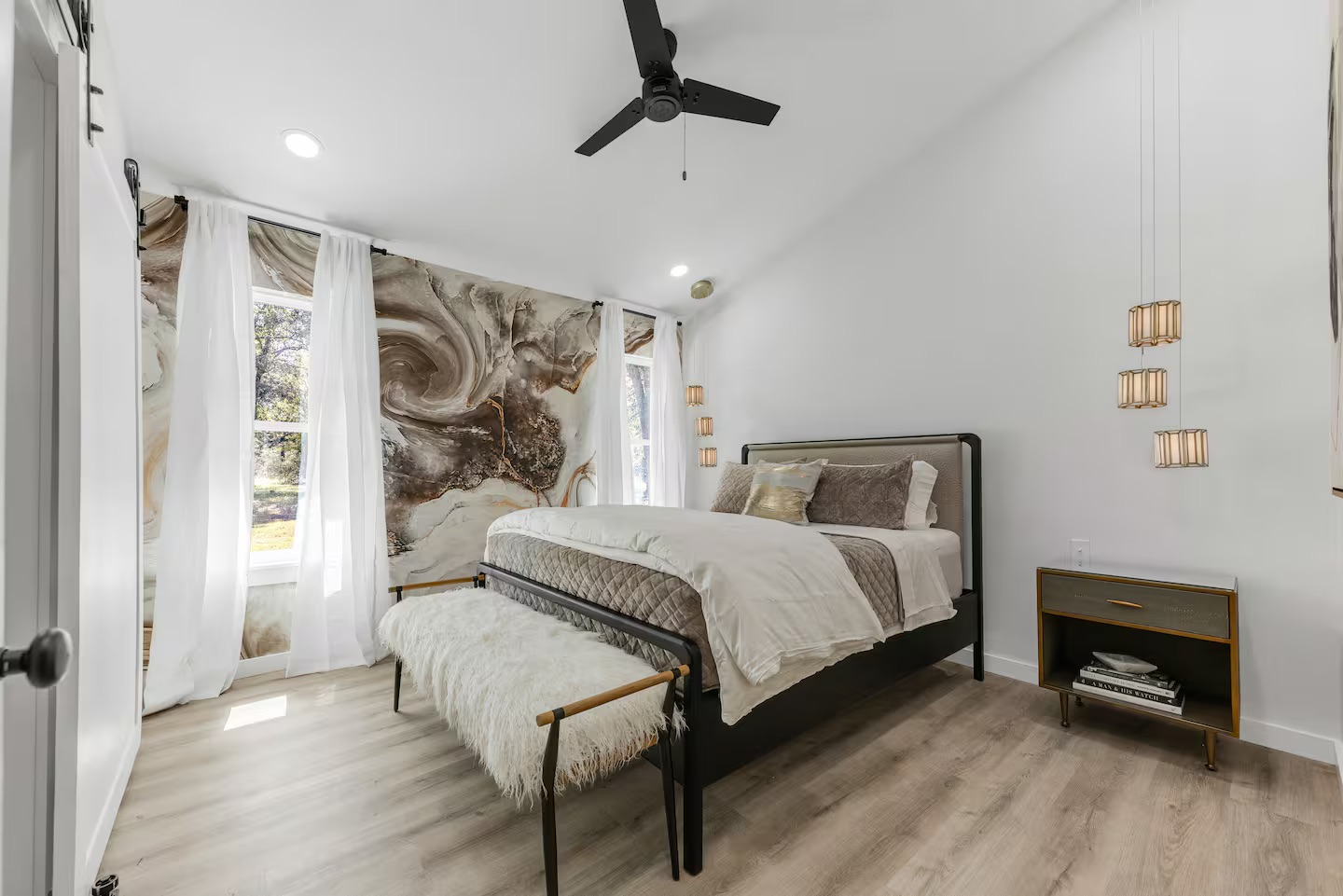 Bedroom with marble pattern wallpaper and pendant lighting
