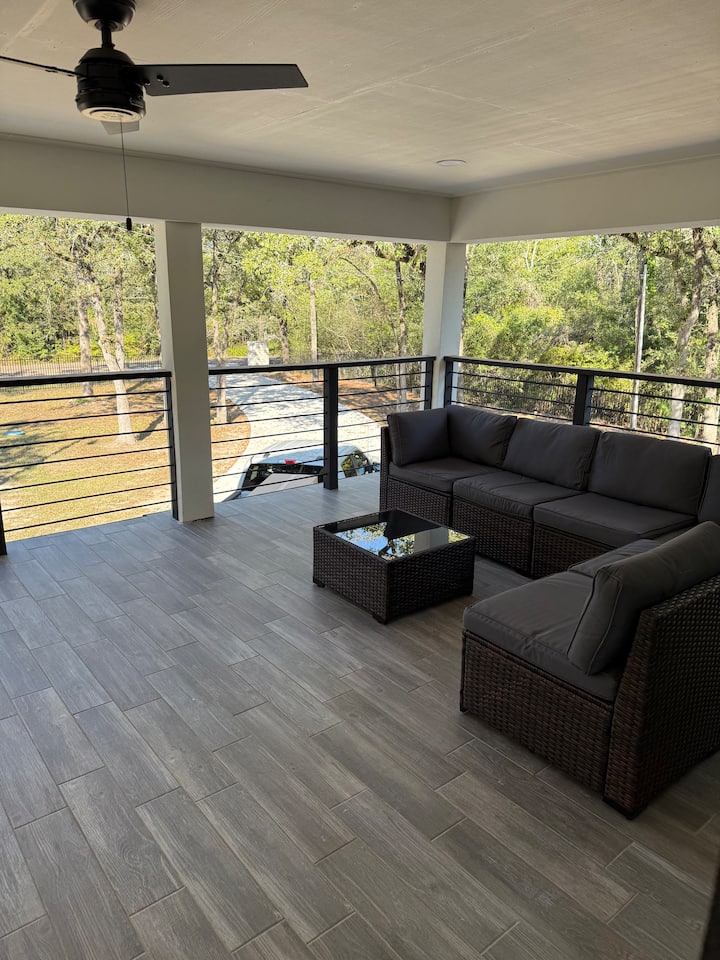 Covered deck with comfortable seating and forest views